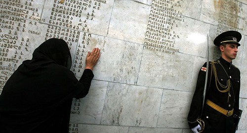Женщина плачет у грузино-абхазского военного мемориала, на котором есть имя ее сына во время юбилейной церемонии в Тбилиси 27 сентября 2006 г. Фото: REUTERS/David Mdzinarishvili (GEORGIA)
