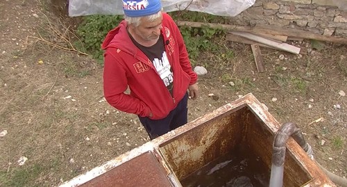 Сельчанин закачивает покупную воду в бак. Кадр видео НТВ https://www.ntv.ru/novosti/2620744/