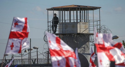 Флаги сторонников Михаила Саакашвили на фоне тюрьмы в Рустави. Фото: REUTERS/Ираклий Геденидзе