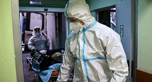 Медицинские работники в защитных костюмах. Фото: REUTERS/Максим Шеметов