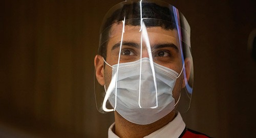 Сотрудник центра государственных услуг в защитной маске и маске для лица. Фото: REUTERS/Maxim Shemetov