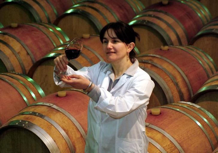 Грузинский специалист держит бокал вина на винограднике в Телави на востоке Грузии, 18 апреля 2006 года. Фото: REUTERS/Stringer