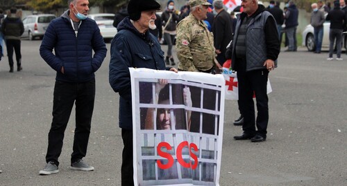 Участник акции протеста с плакатом, на котором фото Саакашвили, выглядывающего в тюремное окно. 6 ноября 2021 г. Фото Инны Кукуджановой для "Кавказского узла"