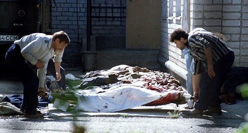 Сотрудники МВД России возле носилок с телом жертвы нападения чеченских боевиков на Буденновск 15 июня 1995 г. Фото: Stringer/Reuters