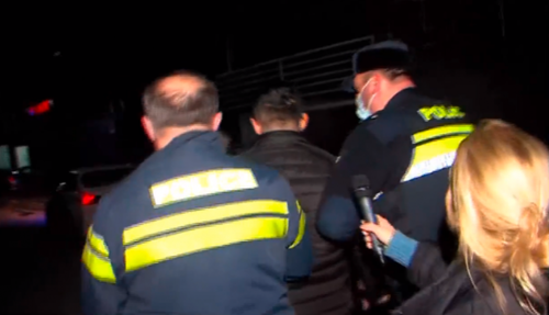 Полиция уводит нападавшего на журналистов. Стоп-кадр видео телеканала "Формула". https://formulanews.ge/News/66843