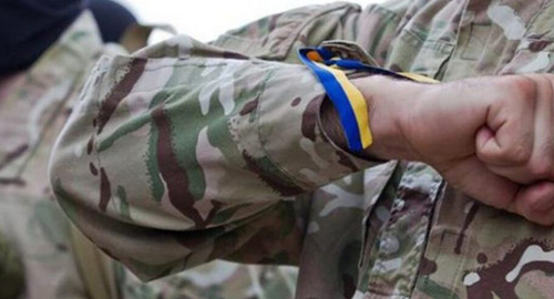 Ленточка с цветами украинского флага на запястье военного. Фото: https://www.newsgeorgia.ge/тела-еще-двух-погибших-в-украине-добро/