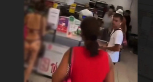 Скриншот видео с туристкой в бикини в супермаркете Сочи.