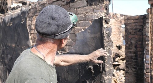 Мужчина осматривает дом после пожара в Верхнекундрюченской. Фото Сергея Снежина для "Кавказского узла".