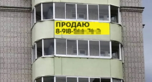Объявление о продаже квартиры в окне дома. Фото: Елена Синеок, "Юга.ру"