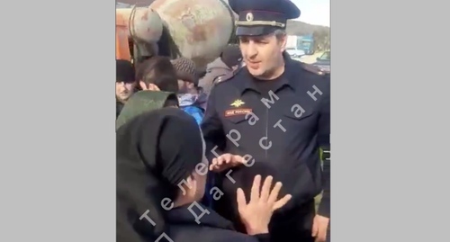Протестующие в Каякенте спорят с офицером полиции. Кадр видео телеграм-канала "ЧП Дагестан/Новости Дагестана" https://t.me/chp_Dagestan1/1082