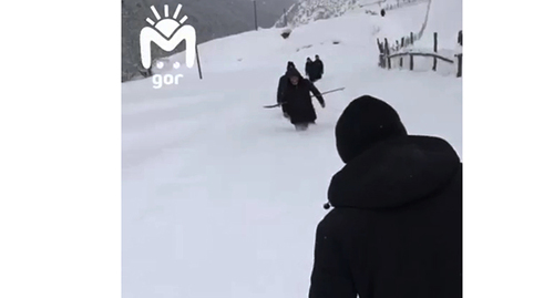 Люди идут по дороге, заваленной снегом, в селе Хутрах Цунтинского района. Скриншот видео https://vk.com/video-24098940_456242311
