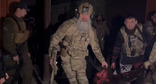Сотрудники силовых структур несут убитого в Гудермесе мужчину. Скриншот видео t.me/RKadyrov_95
