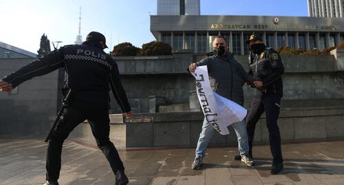 Сотрудники полиции вырывают плакат у протестующего. Фото Азиза Каримова для "Кавказского узла"