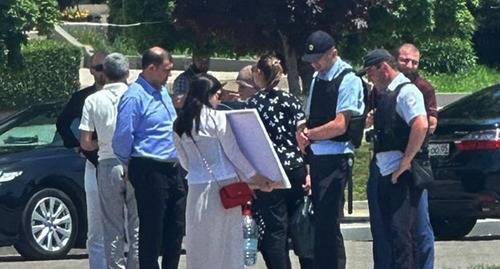 Сотрудники полиции общаются с местной жительницей, которая провела одиночный пикет. Махачкала, 13 июня 2023 г. Скриншот видео https://www.kavkaz-uzel.eu/admin/articles/389598