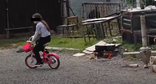 Ребенок в Степанакерте катается на велосипеде около костра, на котором взрослые готовят пищу. Стопкадр из видео https://www.youtube.com/watch?v=2Xp0RzSpu_U