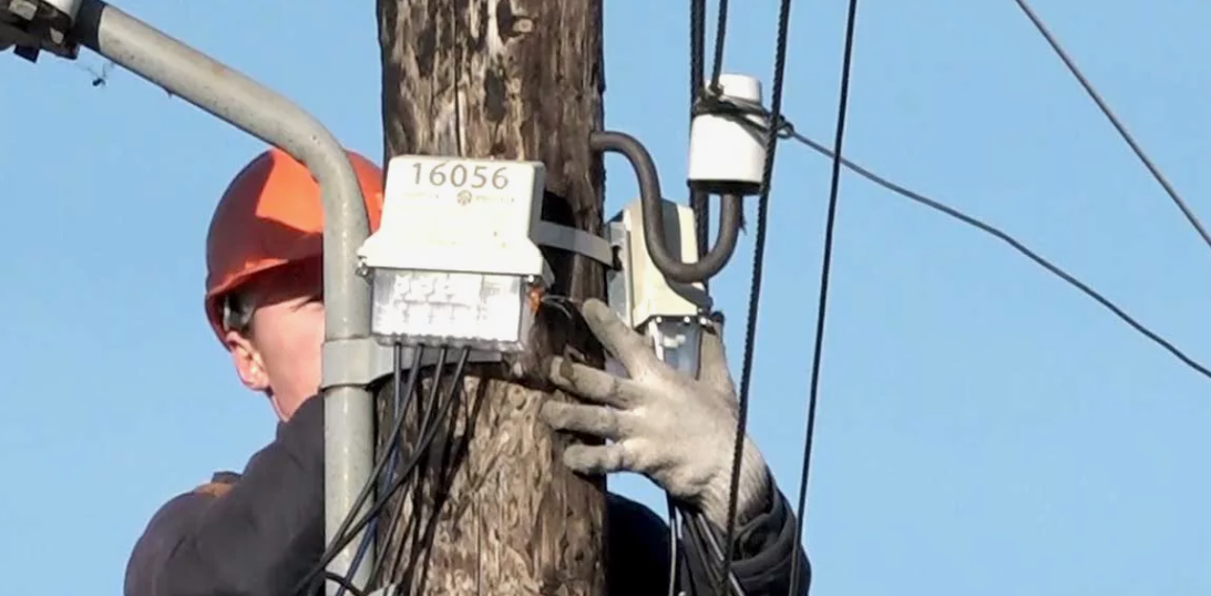 Электрик ремонтирует линию электропередачи. Скриншот фото https://dzertv.ru/tag/schetchiki/page/3/.