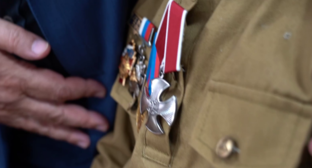 Орден Мужества убитого на СВО отца вручили его дочери. Стоп-кадр видео из Telegram-канала администрации Хасавюрта от 06.09.25, https://t.me/gohasavyurt/19101.