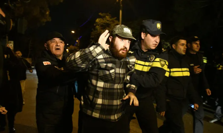 Задержание участника шествия в Тбилиси. Скриншот фото "Интерпрессньюс" от 19.11.25, https://www.interpressnews.ge/ka/article/855075-policiam-mate-devizis-mxardamcheri-msvlelobis-kidev-ramdenime-monacile-daakava