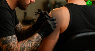 Тату-мастер за работой. Иллюстрация создана «Кавказским узлом» с помощью ИИ в программе Copilot