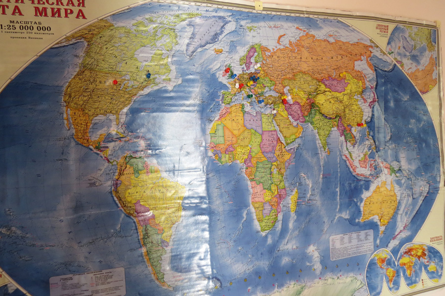 Карта, где цветными иголочками отмечены государства, откуда приехали гости. Не все гости отметились, на Австралии видны две жёлтые иголочки...