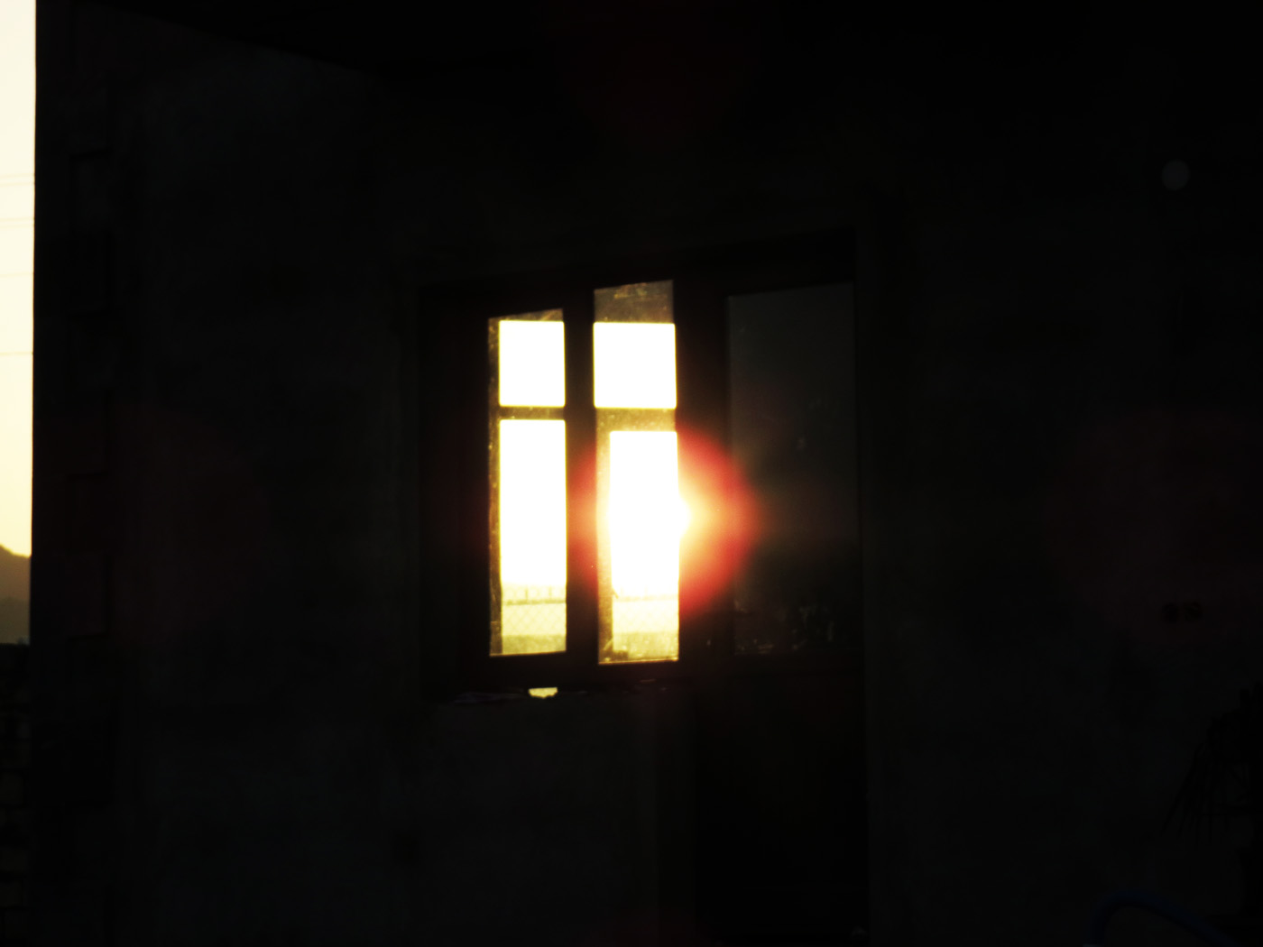 Заходящее солнце сквозь окно недостроенного дома.