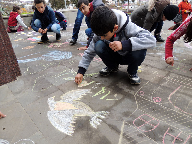 На площадке школы №5 дети рисуют рисунки, посвящённые дню Мира.
