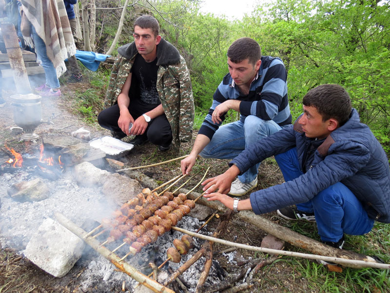 Ребята на углях готовят картошечку.