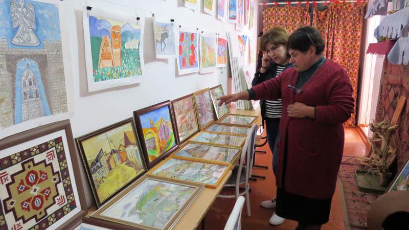 Директор центра Ирина Тамразян (слева) показывает работы детей.