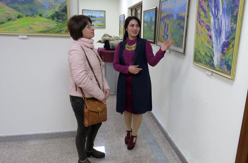 Искусствовед Ани Авансян говорит посетительнице о работе художника.