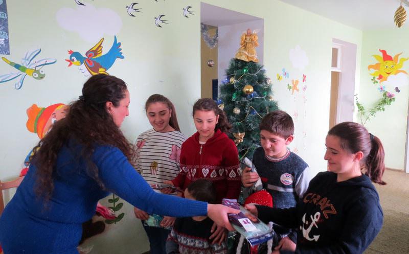 Сотрудница дома-интерната Карина Осипян раздаёт детишкам колготки, носочки пр.